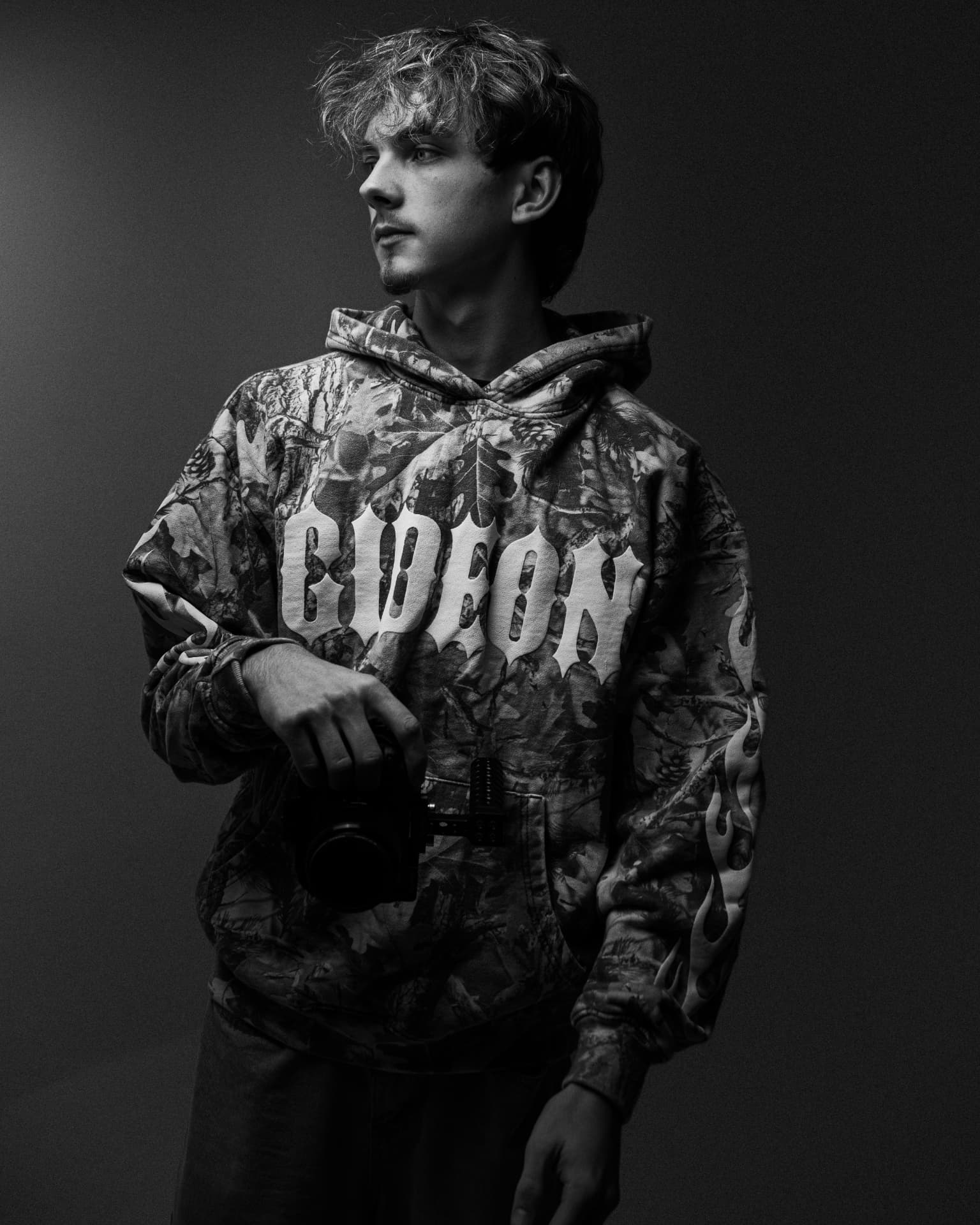 Blaise Diamond in studio holding a camera