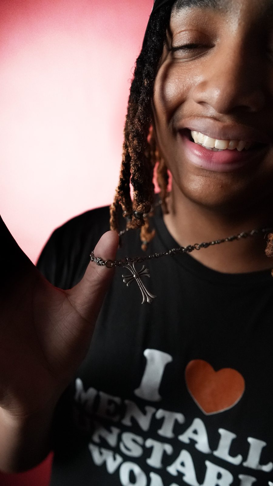 Artist laughing mid-shoot on a red backdrop