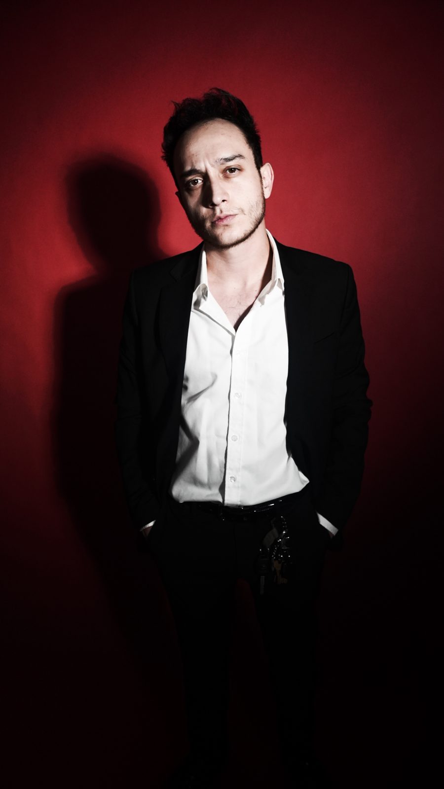 Portrait in a black suit and open white shirt